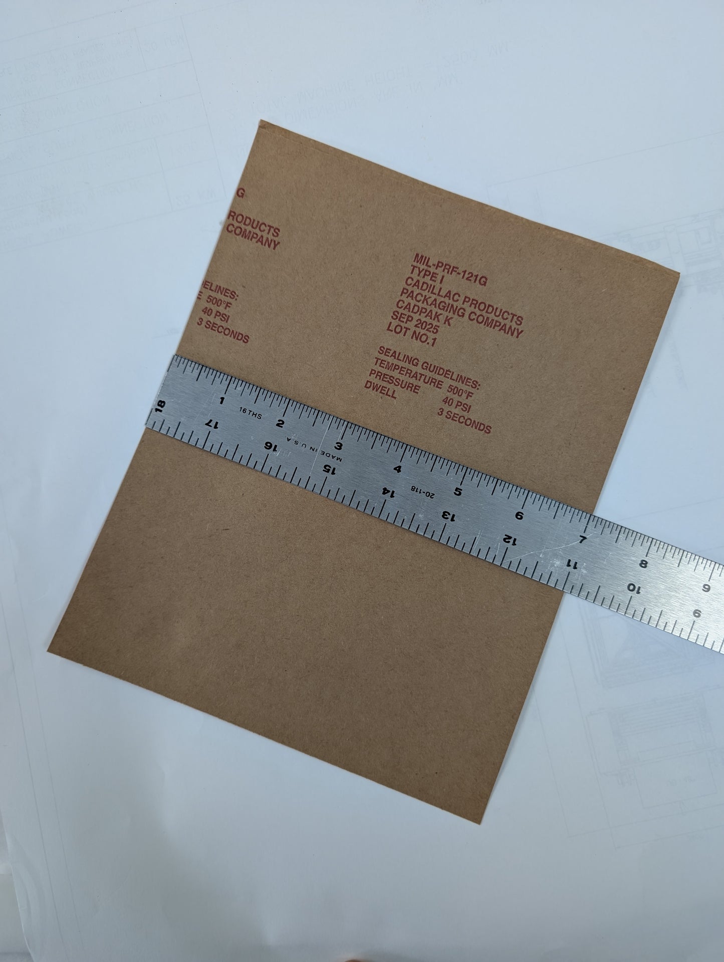 Brown bag with a ruler on top, showing measurements against a light gray background