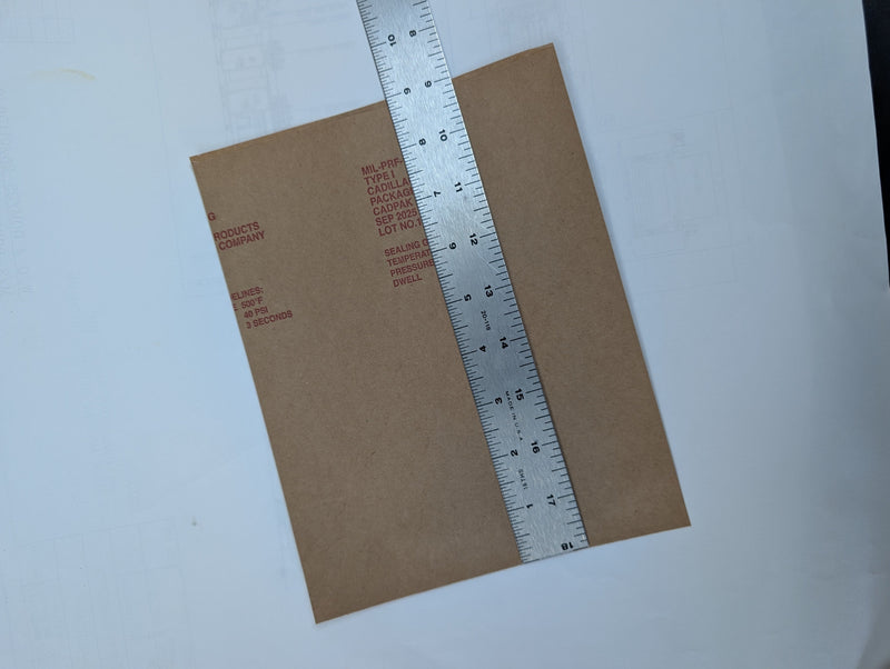 Brown paper bag with a ruler for measurement on a white background
