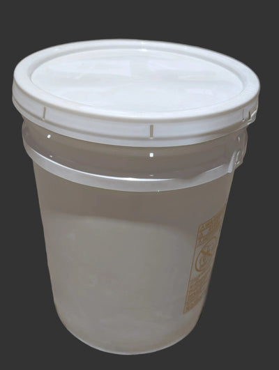 White bucket with a lid on a concrete floor in an industrial setting